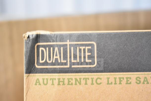 Cardboard box displaying "DUAL LITE" logo. Box corner slightly damaged. Contains new DualLite EVODW Double Remote Head, Exit Sign.