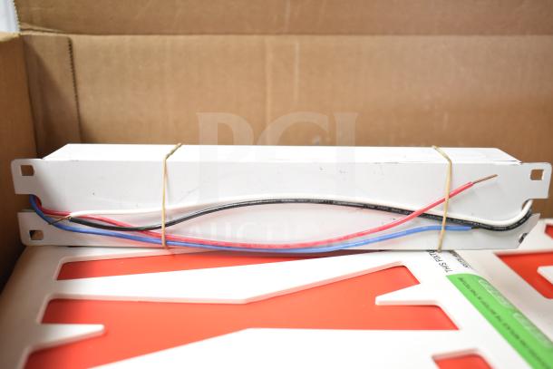 Box containing various brand new items, including a DualLite EVODW Double Remote Head and DualLite Exit Sign.