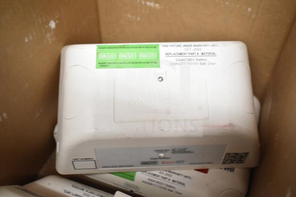 Box containing new DualLite EVODW remote head units, visible labels indicate battery compartment and warranty details.