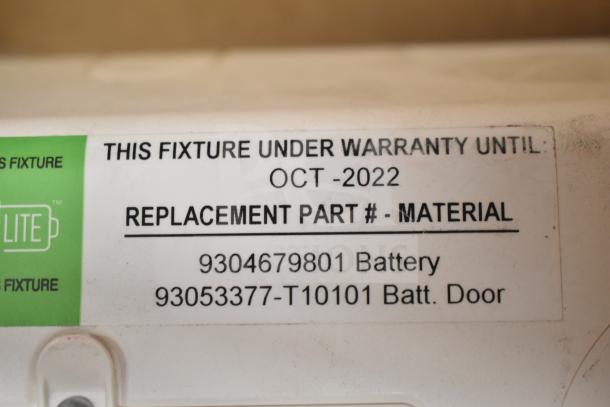 Label on DualLite fixture indicates warranty until Oct 2022, with replacement part numbers for battery and door.