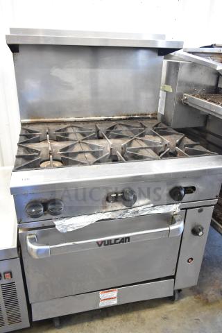 Vulcan 36S-Y1A commercial gas range with 6 burners, oven, overshelf, backsplash, on casters, 215,000 BTU, in used condition.