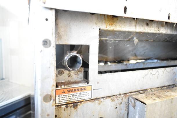 Vulcan 36S-Y1A commercial gas range with 6 burners, oven, over shelf, backsplash, commercial casters. 215,000 BTU. Warning label visible.