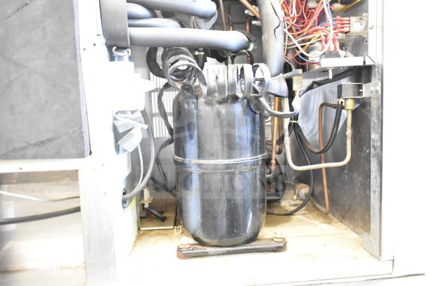 Hoshizaki KM-1301SWH commercial ice head on bin, 208-230 volts, 1 phase. Intricate internal components visible.