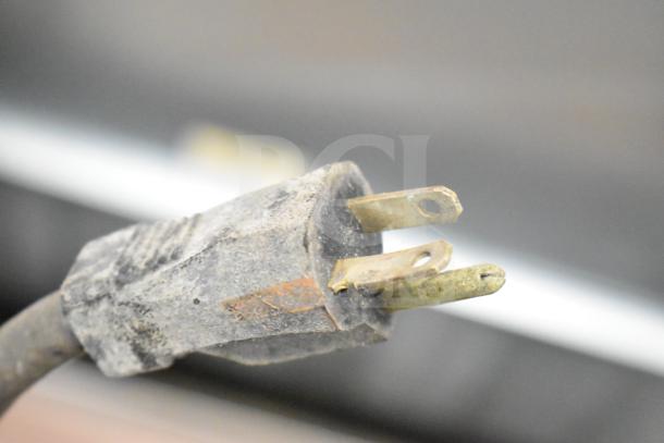 Close-up of a worn power plug for a 208-volt, 1-phase electric countertop flat top griddle.