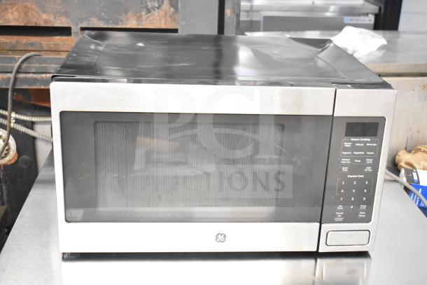 2019 General Electric JES1657SM1SS countertop microwave oven. Stainless steel exterior, 120 volts, visible minor wear.
