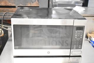 2019 General Electric JES1657SM1SS countertop microwave oven. Stainless steel exterior, 120 volts, visible minor wear.