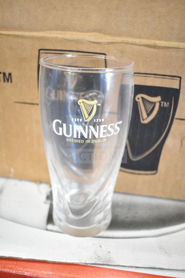 Guinness 16 oz glass with logo, made in Dublin, clear glass with box in the background. Perfect for collectors.