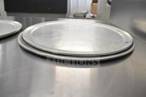 Stack of metal trays, part of an auction lot of 15 items including chafing dish frames. Visible wear, good condition.