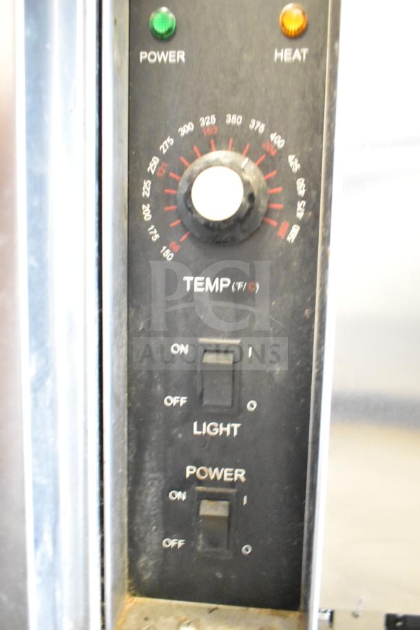 Seagate convection oven control panel with temperature dial, power and light switches. Commercial use, visible wear.