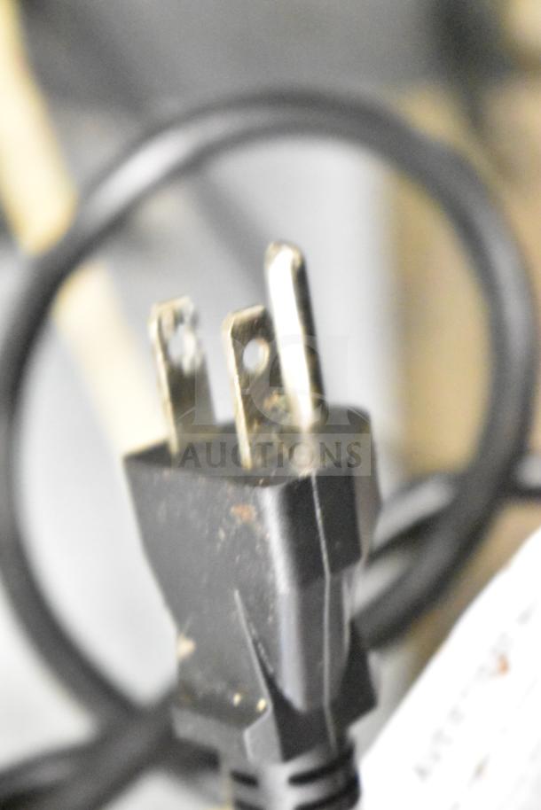 A close-up of a power plug for Seagate commercial convection ovens, showing a standard three-prong configuration.