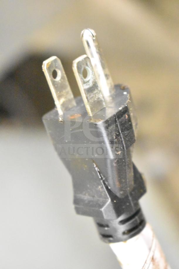 Close-up of a power plug for Seagate convection ovens. Image shows a standard, slightly worn three-prong plug.