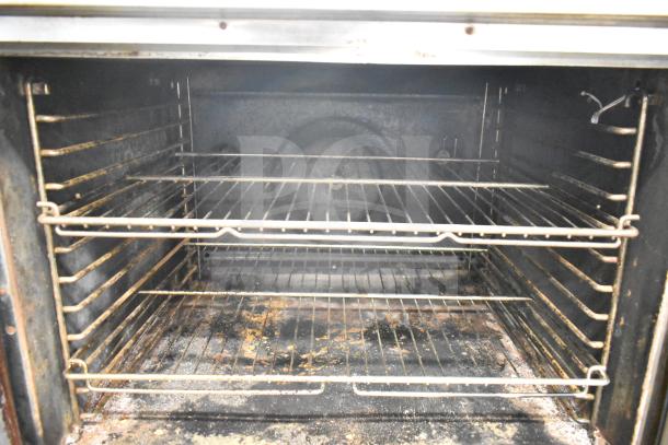Blodgett DFS-100 convection oven interior, view through doors, with metal racks, showing wear and residue.
