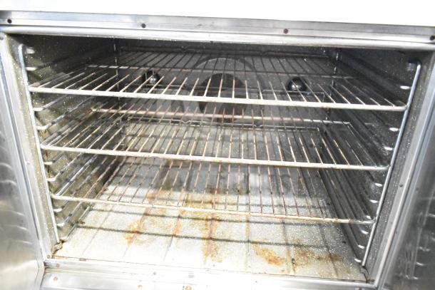 Blodgett commercial gas convection oven interior with multiple racks, showing signs of wear and some rust on the base.