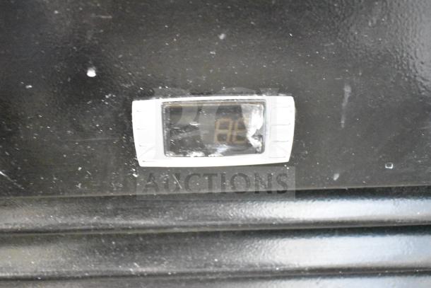 Dukers DSM-68SR cooler temperature display, digital screen, part of commercial 3-door reach-in merchandiser.