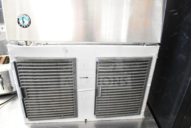 Hoshizaki undercounter ice machine, commercial grade, self-contained, 115 volts, visible vents, Hoshizaki logo, moderate wear.