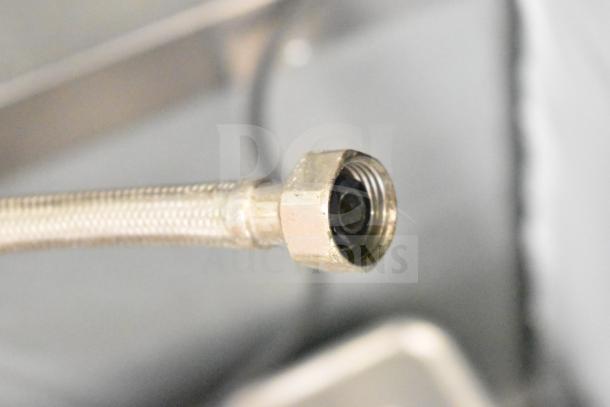 Close-up of a connector hose for a Hoshizaki commercial undercounter ice machine, showcasing the metal fitting end.