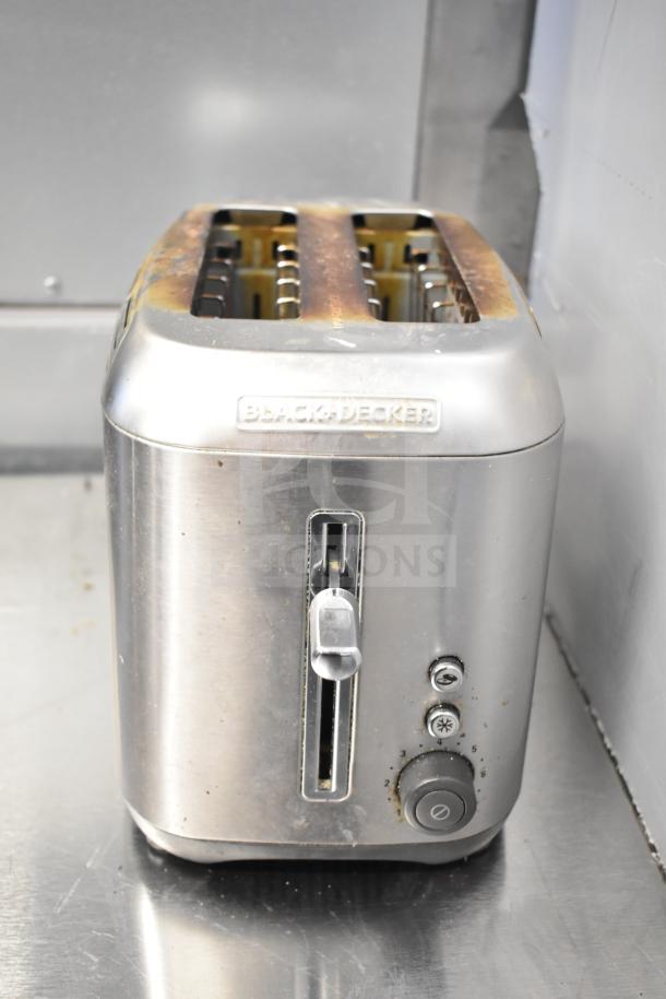 Black & Decker 2-slot toaster in used condition, visible wear. Stainless steel finish with control buttons on the front.