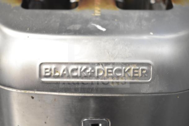 Black & Decker 2-slot toaster, silver finish, visible wear, Black & Decker logo embossed on front.