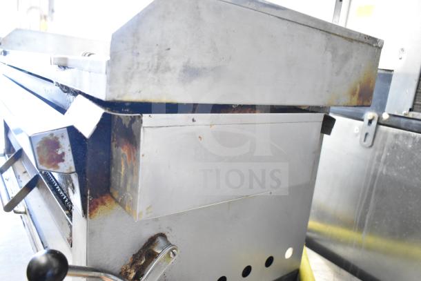 Commercial gas-powered flat top griddle with cheese melter, featuring visible wear and rust, ideal for kitchen use.