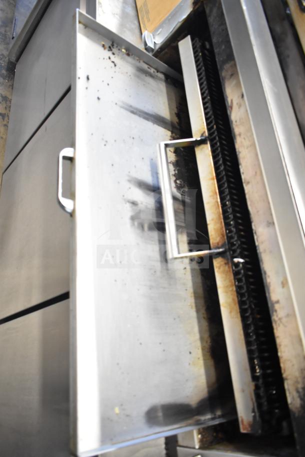 Commercial gas-powered flat top griddle with attached cheese melter. Stainless steel surface, showing signs of use.