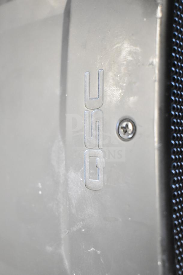 Close-up of QSC speaker showing brand logo, part of an auction lot including eight miscellaneous items.
