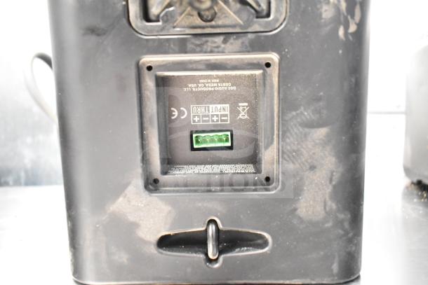 QSC AD-S6T speaker rear view with input panel, connection ports, and markings. Includes Crestron speaker, 8 items total.