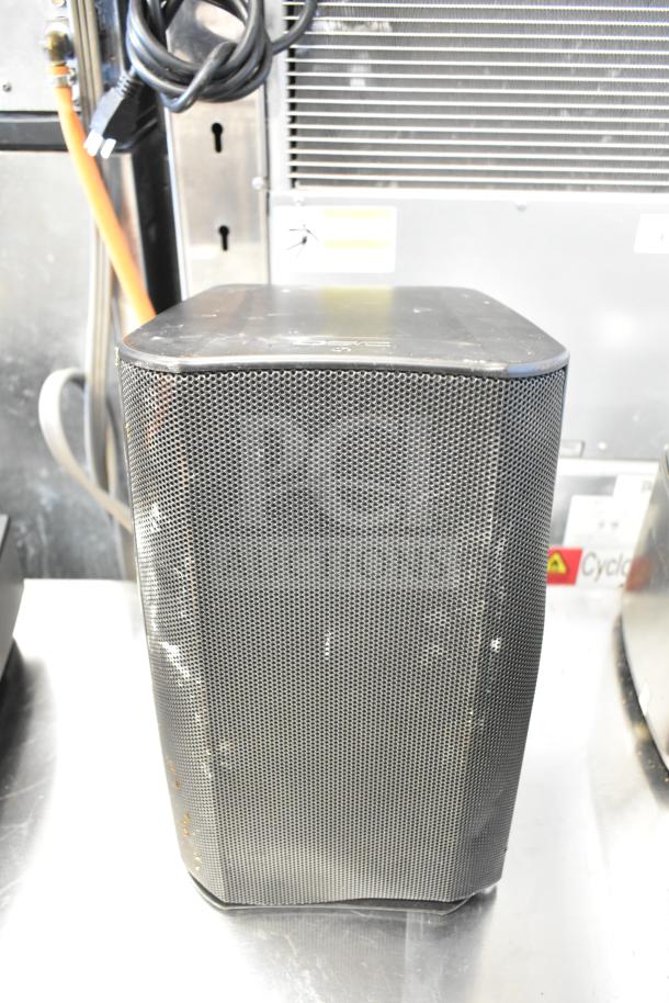 QSC AD-S6T speaker with a black metal grille, minimal wear, and visible power cord; auction includes 8 items.