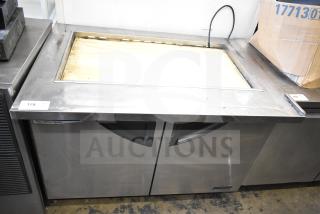 Turbo Air TST-48SD-18 prep table, stainless steel, two doors, 115 volts, labels visible, used condition.
