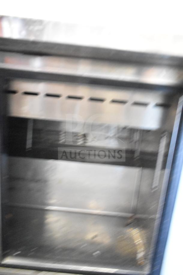 Turbo Air TST-48SD-18 prep table interior, stainless steel, well-used condition, 115V, 1 phase, visible internal shelving.