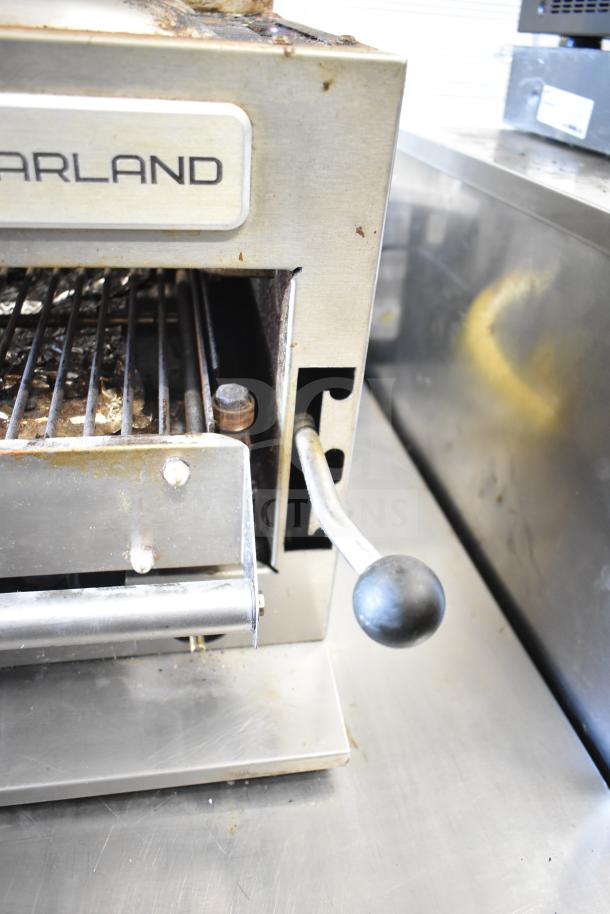 Garland Commercial Gas Cheese Melter with steel finish, visible wear. Features adjustable handle, grill rack, and Garland label.