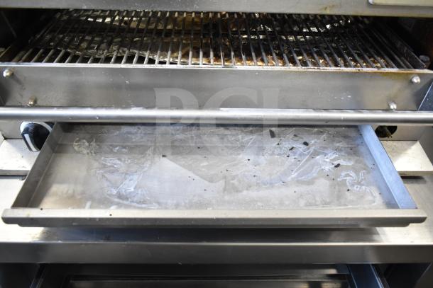 Garland Commercial Gas Powered Cheese Melter, stainless steel, used condition, grilling rack and sliding tray visible.