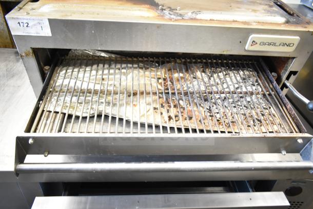 Garland commercial gas-powered cheese melter with visible wear and rust. Features a grilling rack. Model tag present.