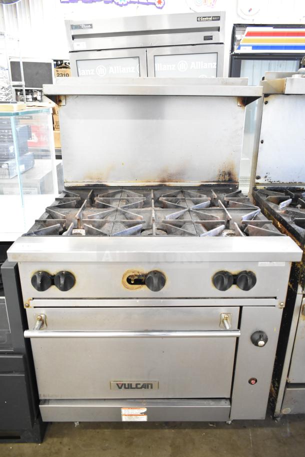 Vulcan 36S-6BN commercial natural gas-powered range with six burners, oven, over shelf, and backsplash, visible wear.