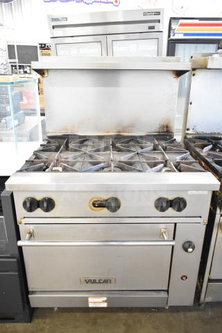 Vulcan 36S-6BN commercial natural gas-powered range with six burners, oven, over shelf, and backsplash, visible wear.