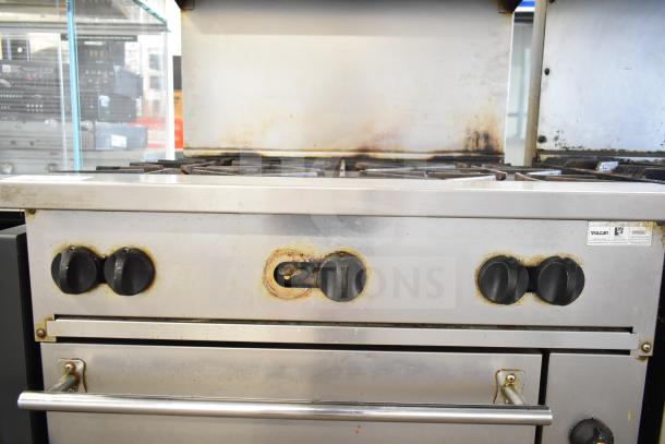 Vulcan 36S-6BN commercial gas range with 6 burners, oven, overshelf, and backsplash. Visible wear and Vulcan label.