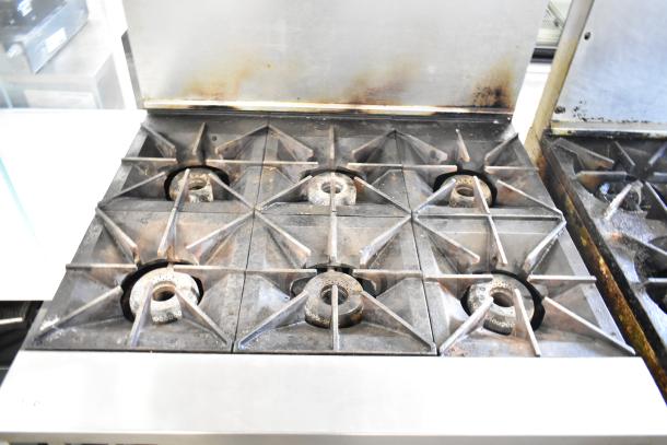 Vulcan 36S-6BN commercial natural gas 6-burner range, includes oven, over shelf, and backsplash, showing wear.