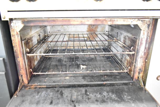 Vulcan 36S-6BN commercial gas range oven interior showing signs of use, wire racks, and a metal interior surface.