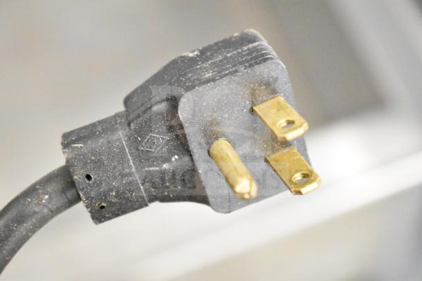 Close-up of a power plug for an Atlas Metals RM-3 Commercial Refrigerated Drop In, showing prongs and slight wear.