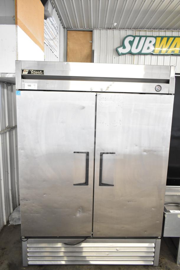 True T-49F commercial 2-door reach-in freezer, stainless steel, 115 volts, 1 phase, with visible exterior wear, True branding label.