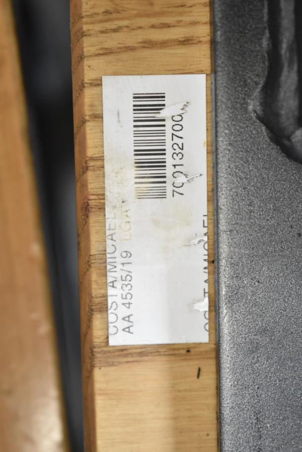 Wooden dining table with metal legs, includes visible label and barcode on wood surface, good condition.