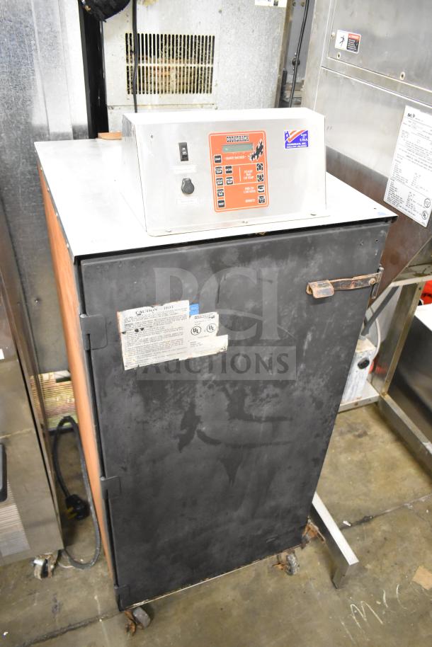 CookShack 250 electric smoker cabinet on commercial casters, 208 volts, visible control panel, used condition with caution label.