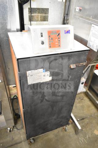 CookShack 250 electric smoker cabinet on commercial casters, 208 volts, visible control panel, used condition with caution label.