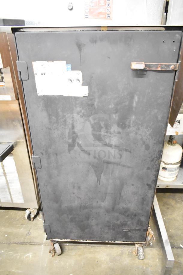 CookShack 250 Commercial Electric Smoker Cabinet, condition showing wear, on casters. Tags include UL certification. 208 volts.
