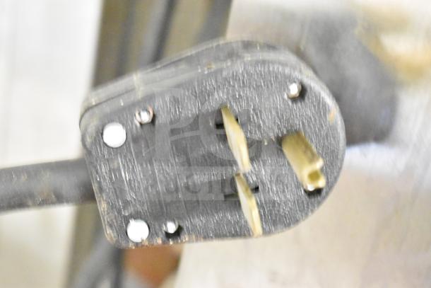 Close-up of a black electrical plug with visible screws, showing wear, likely part of a BKI Commercial Hood.