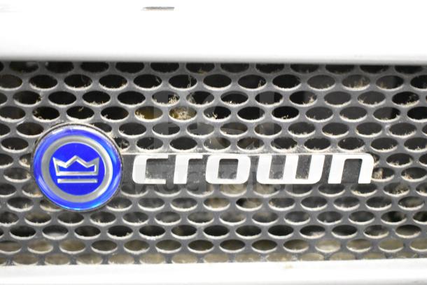 Crown XLS 1500 Power Amplifier with blue logo, visible on metal grille. Good condition, minor dust accumulation.
