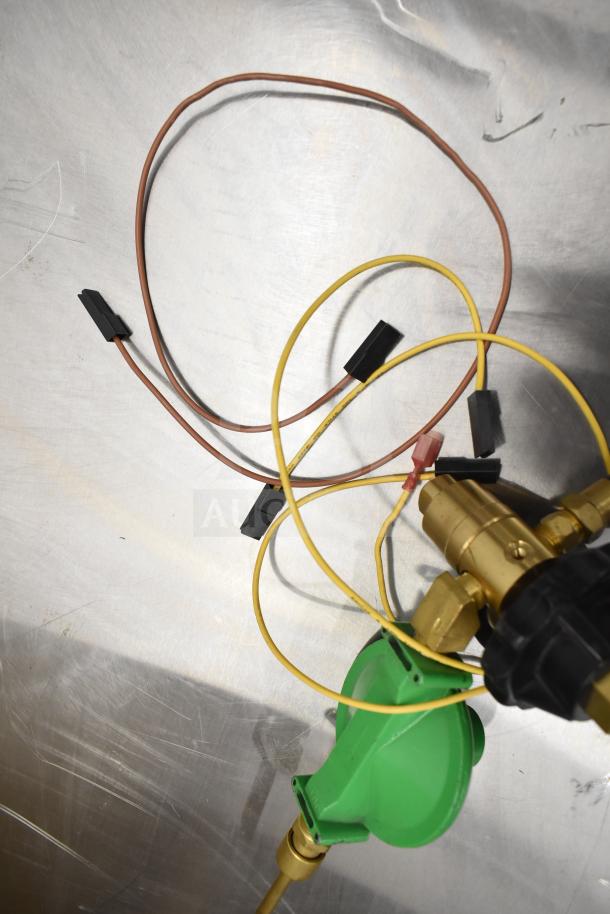 Gas regulator gauge with green body, brass fittings, and attached wires. Features new, unused condition.