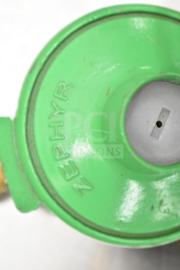 Green Zephyr gauge with visible central opening, displaying minor wear. Distinct "ZEPHYR" branding on surface.