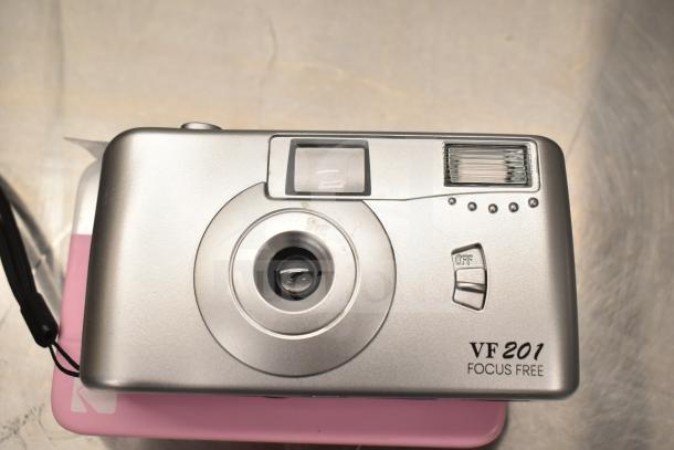 Silver VF201 Focus Free film camera on Kodak Printomatic box, visible lens and flash, in good condition.