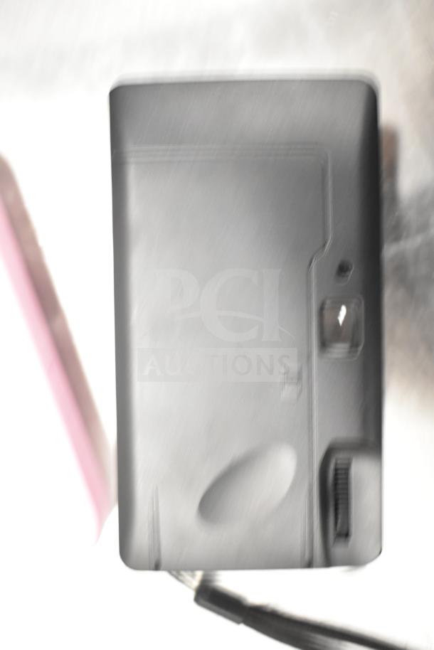 Blurry close-up of a gray camera. Specific features and details are unclear due to image quality.