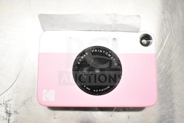 Kodak Printomatic 8mm camera, pink, good condition; features include instant photo printing, lens details visible.